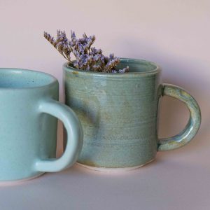 Two ceramic mugs with lavender sprigs inside one of them