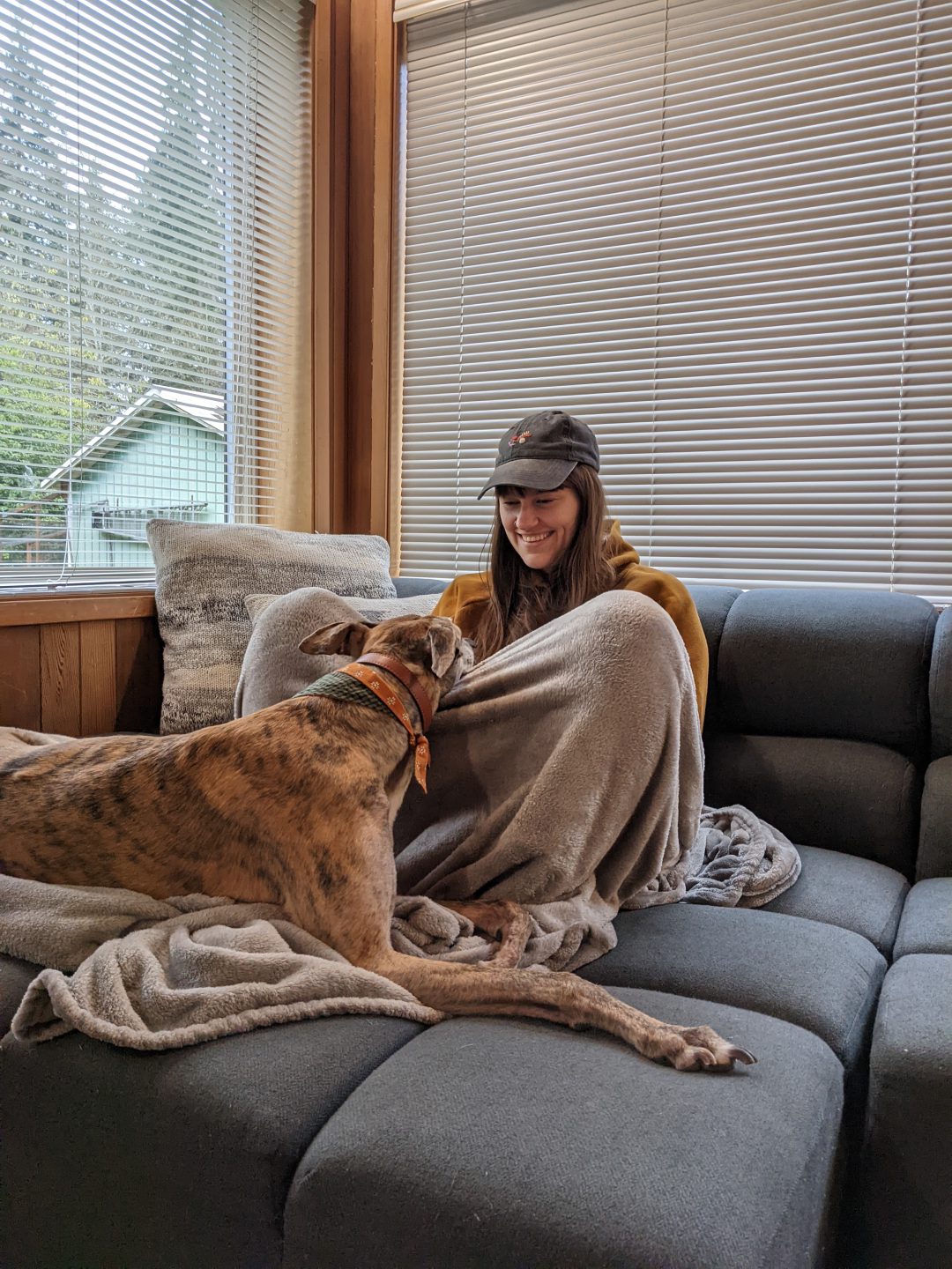 kaila and greer sit facing each other on a couch with a cozy blanket